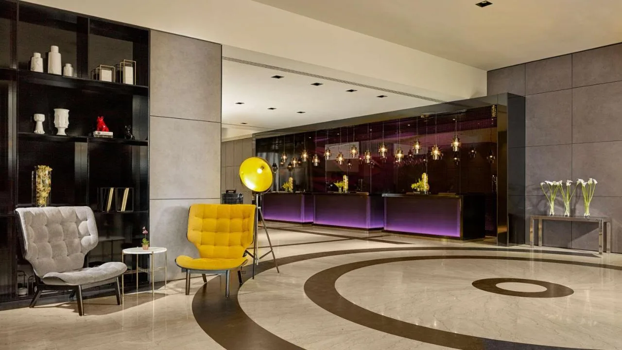 a lobby with a yellow chair and purple chairs at Park Plaza London Victoria in London