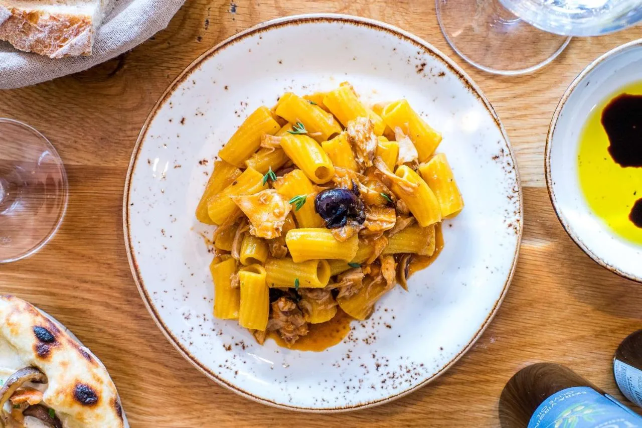 a plate of pasta on a wooden table at Park Plaza London Victoria in London