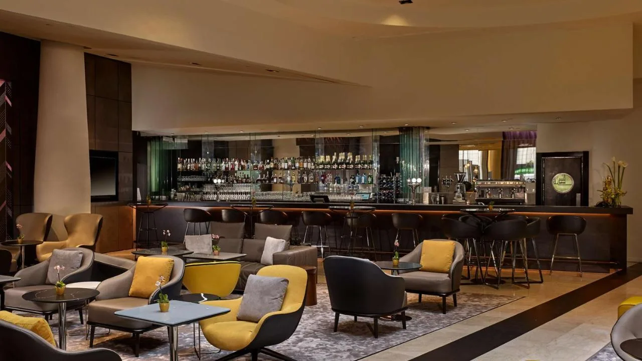 a restaurant with a bar with chairs and tables at Park Plaza London Victoria in London